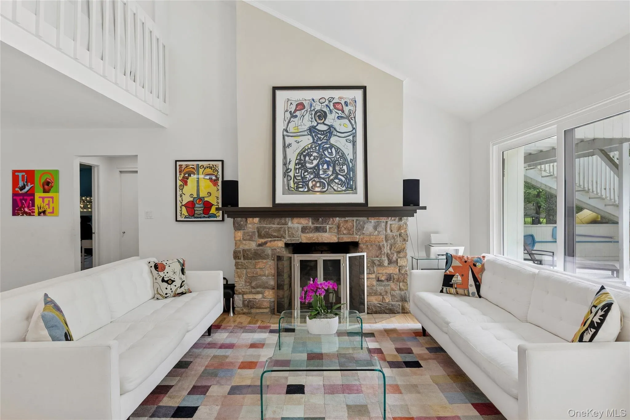 Living area featuring high vaulted ceiling, stairs, and a fireplace Living area featuring high vaulted ceiling, stairs, and a fireplace