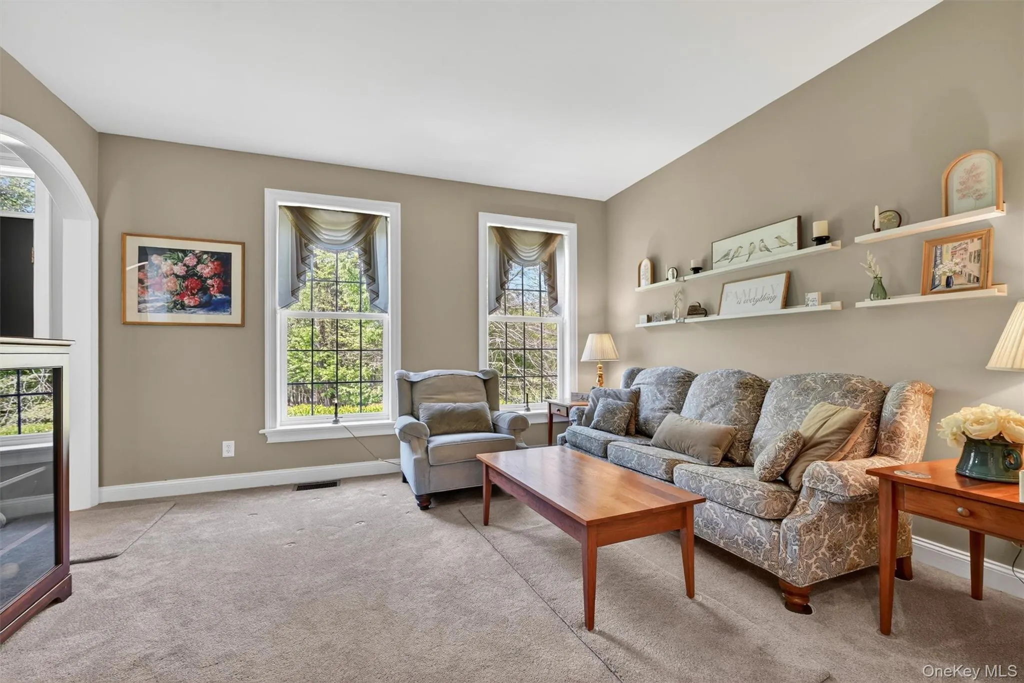 Living room with large windows and arched doorway Living room with large windows and arched doorway