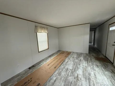 Spare room with crown molding and wood finished floors Spare room with crown molding and wood finished floors