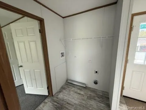 Laundry room with crown molding, laundry area, wood finished floors, and electric dryer hookup Laundry room with crown molding, laundry area, wood finished floors, and electric dryer hookup