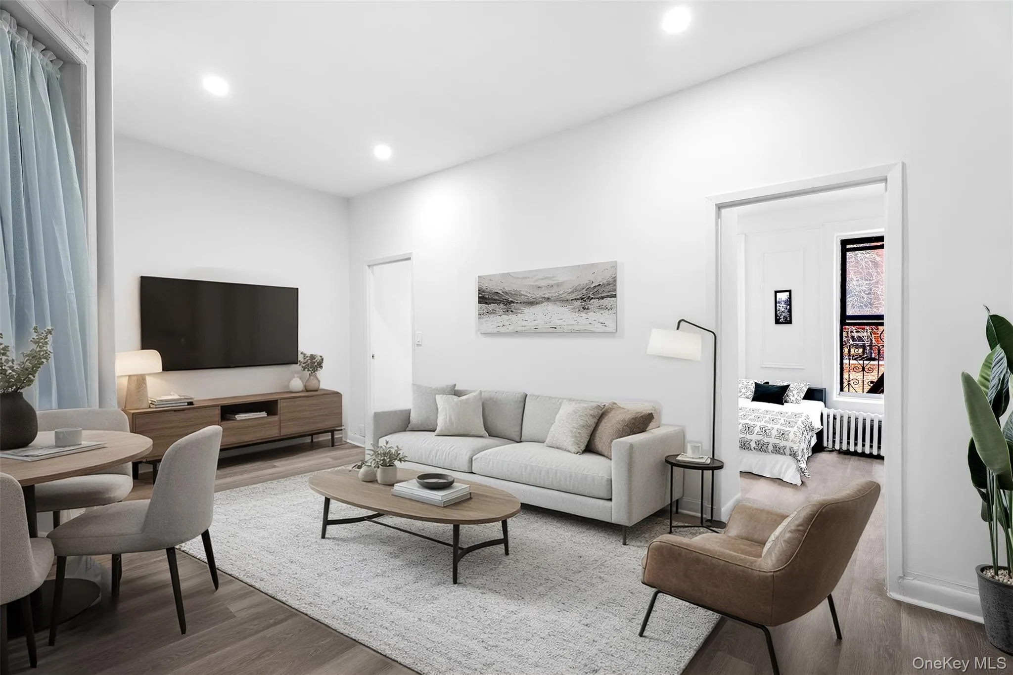 Living room featuring wood finished floors, radiator, and recessed lighting Living room featuring wood finished floors, radiator, and recessed lighting