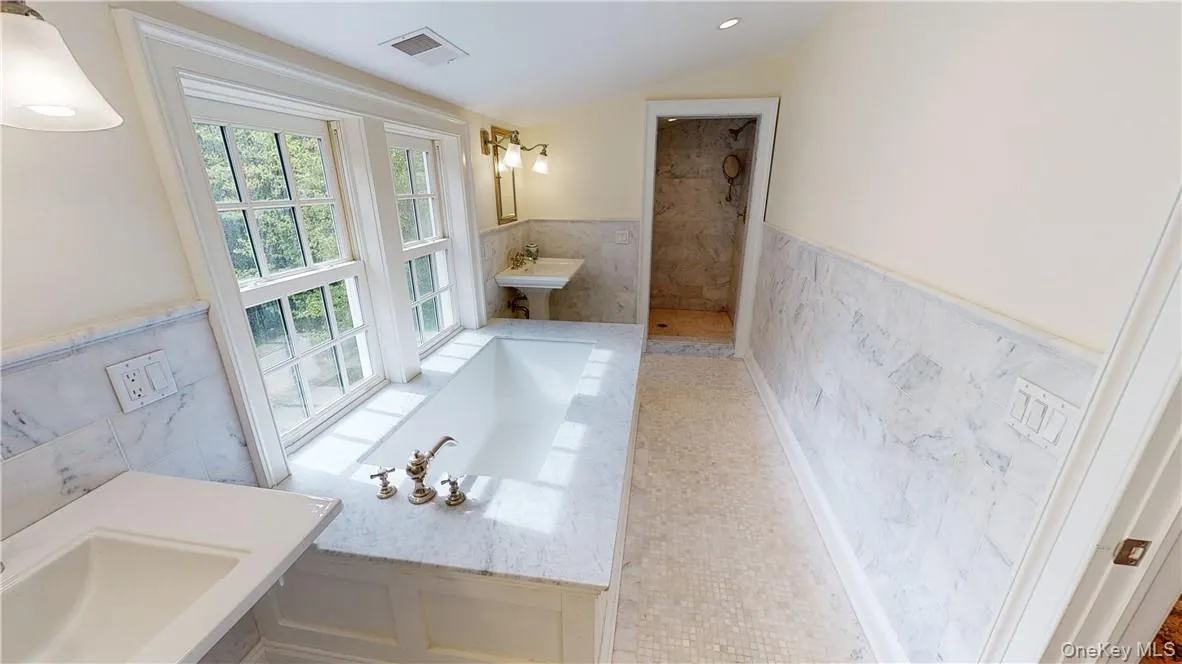 Primary suite bath with walk-in shower at far end and water closet at opposite end Primary suite bath with walk-in shower at far end and water closet at opposite end