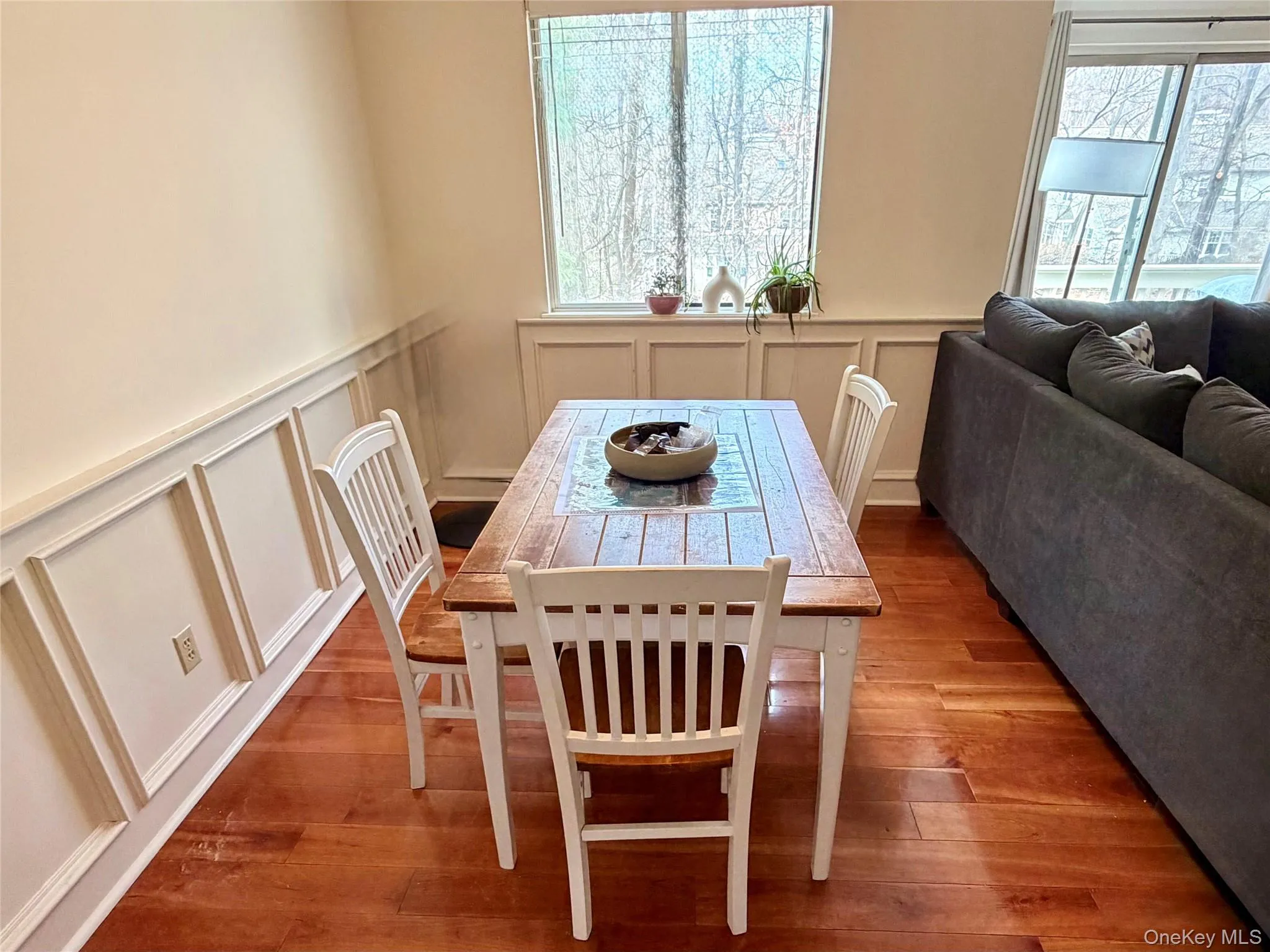 The dining room is one of the standout spaces in this unit, featuring gleaming Brazilian cherry hardwood floors and classic wainscot paneling that adds warmth and detail. The dining room is one of the standout spaces in this unit, featuring gleaming Brazilian cherry hardwood floors and classic wainscot paneling that adds warmth and detail.