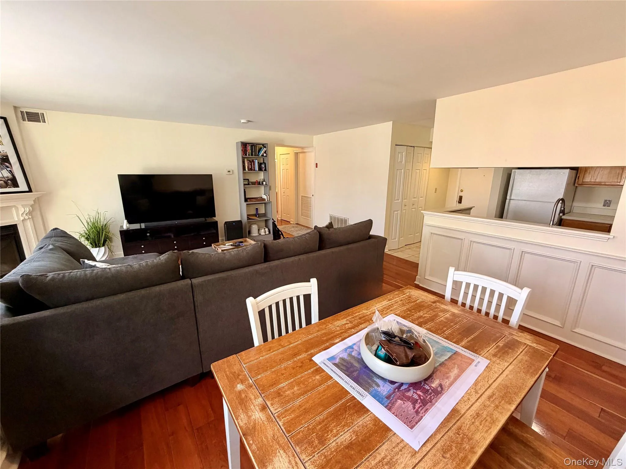 From the dining room you get the full picture of how the living space flows, with hardwood floors, wainscot detail, and the kitchen pass-through keeping everything connected and functional. From the dining room you get the full picture of how the living space flows, with hardwood floors, wainscot detail, and the kitchen pass-through keeping everything connected and functional.