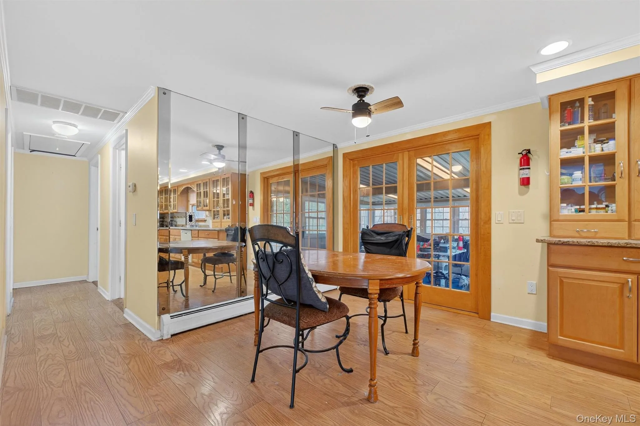 Dining space with ceiling fan, light wood-style flooring, a baseboard heating unit, crown molding, and attic access Dining space with ceiling fan, light wood-style flooring, a baseboard heating unit, crown molding, and attic access