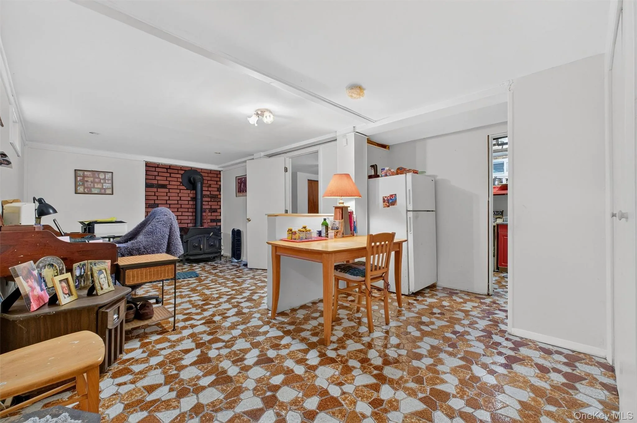 Kitchen featuring freestanding refrigerator and a wood stove Kitchen featuring freestanding refrigerator and a wood stove