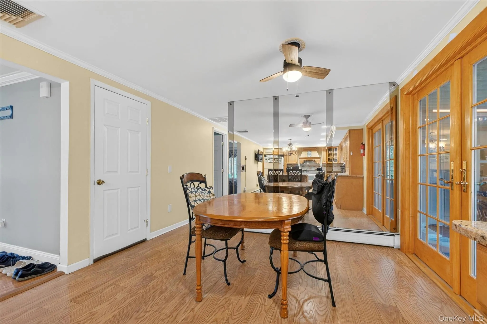 Dining area featuring crown molding, light wood-type flooring, french doors, and a ceiling fan Dining area featuring crown molding, light wood-type flooring, french doors, and a ceiling fan