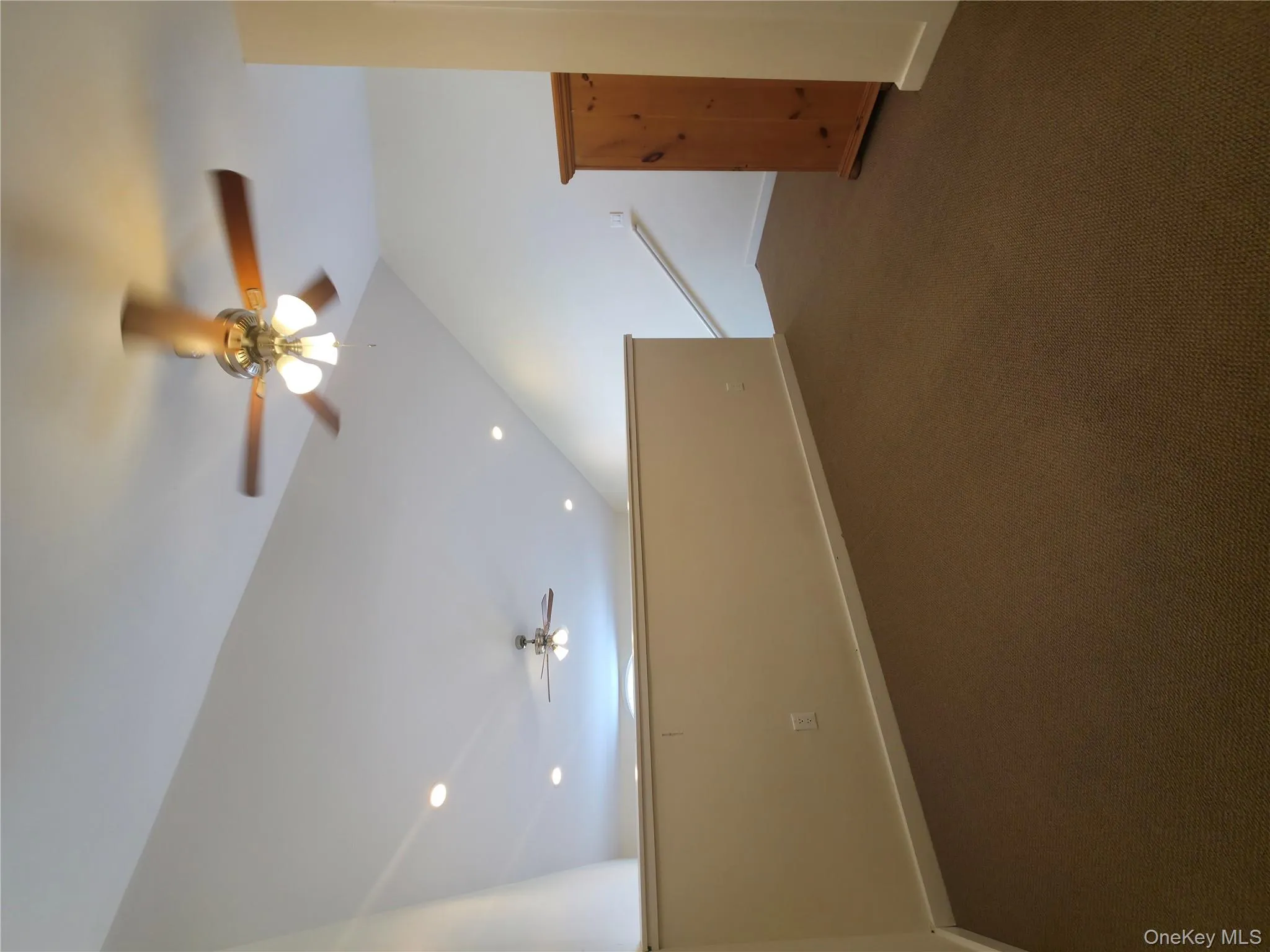 Bonus room with a ceiling fan, lofted ceiling, baseboards, and dark colored carpet Bonus room with a ceiling fan, lofted ceiling, baseboards, and dark colored carpet