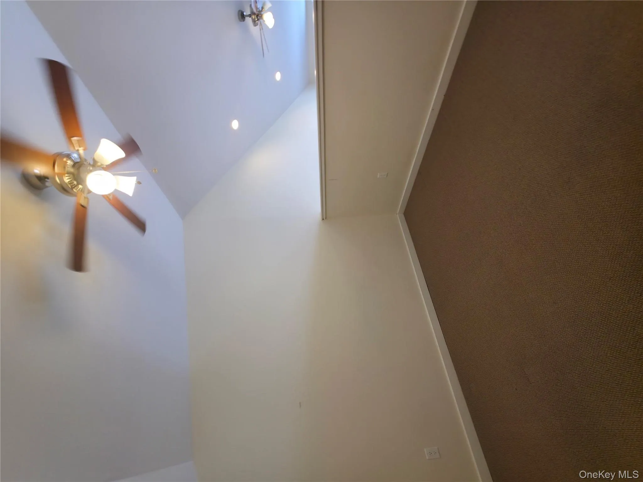 Bonus room with lofted ceiling, ceiling fan, dark carpet, and baseboards Bonus room with lofted ceiling, ceiling fan, dark carpet, and baseboards