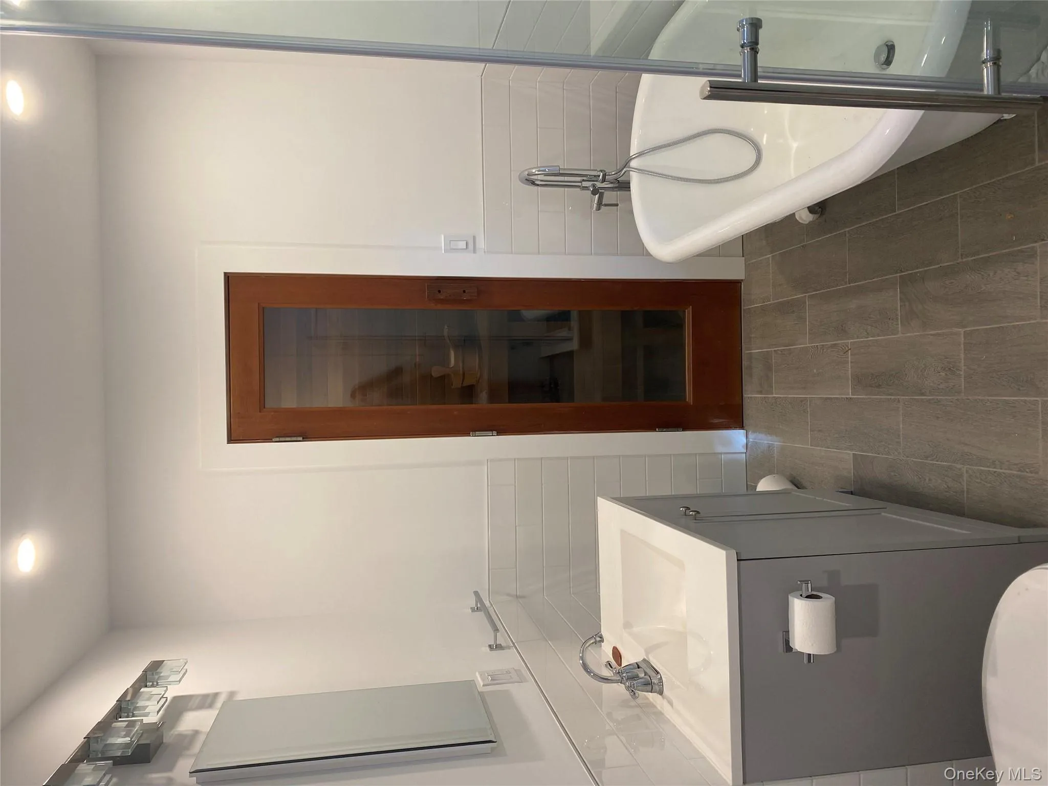 Full bath with tile walls, vanity, a soaking tub, a wainscoted wall, and a relaxing sauna Full bath with tile walls, vanity, a soaking tub, a wainscoted wall, and a relaxing sauna