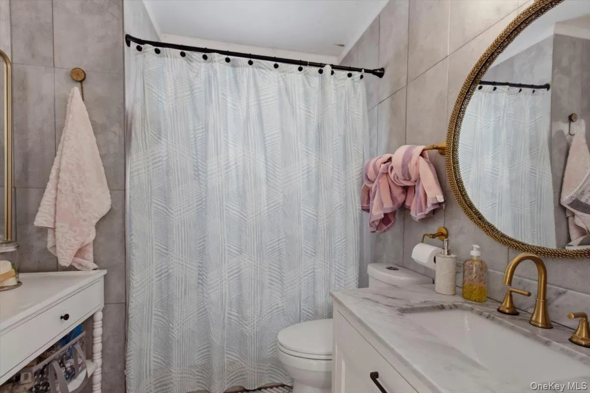 Bathroom with vanity, a shower and tile walls Bathroom with vanity, a shower and tile walls