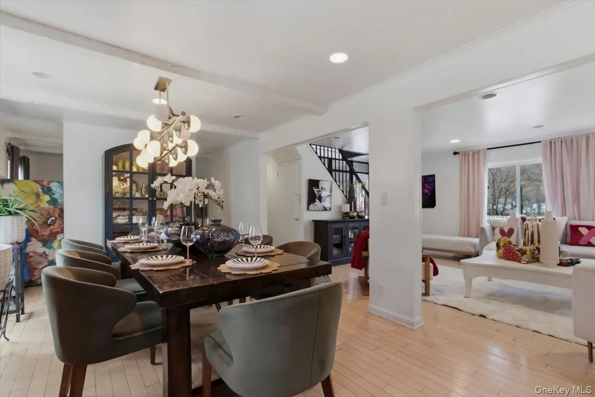 Dining area featuring light wood-style flooring, beam ceiling, and suspended lighting Dining area featuring light wood-style flooring, beam ceiling, and suspended lighting