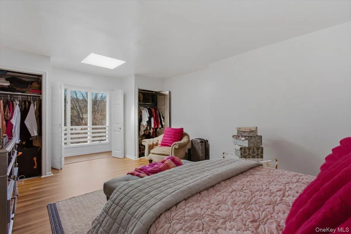 Other view of master bedroom with a skylight and wood finished floors Other view of master bedroom with a skylight and wood finished floors