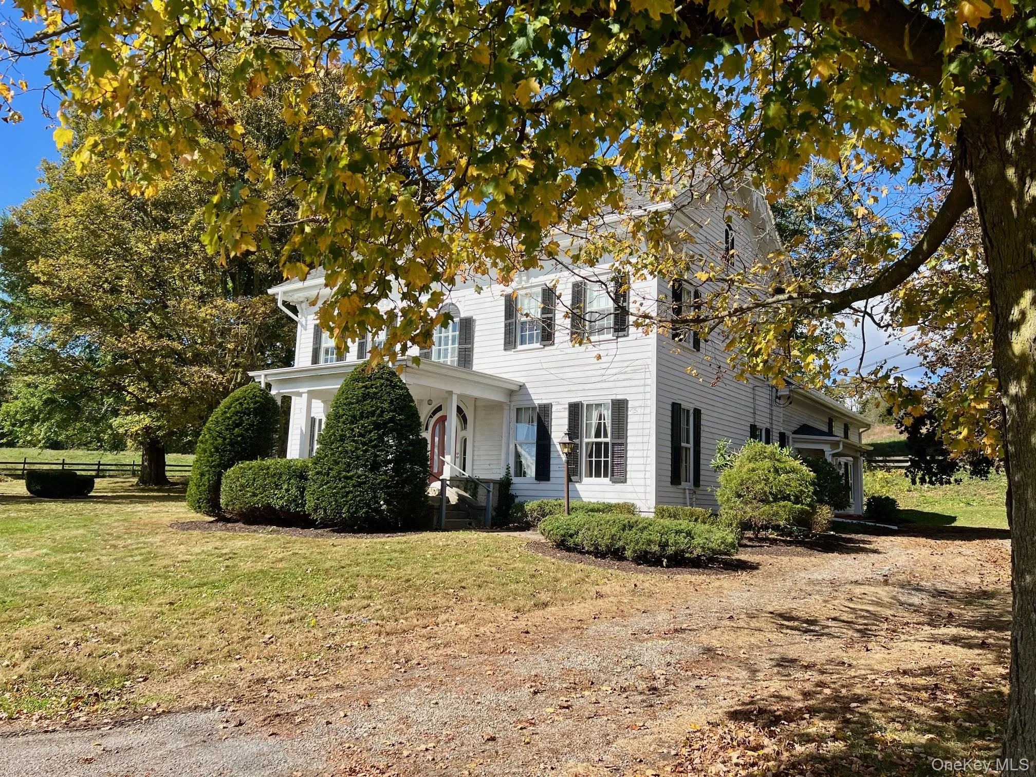 Colonial home featuring a front yard and covered porch Colonial home featuring a front yard and covered porch