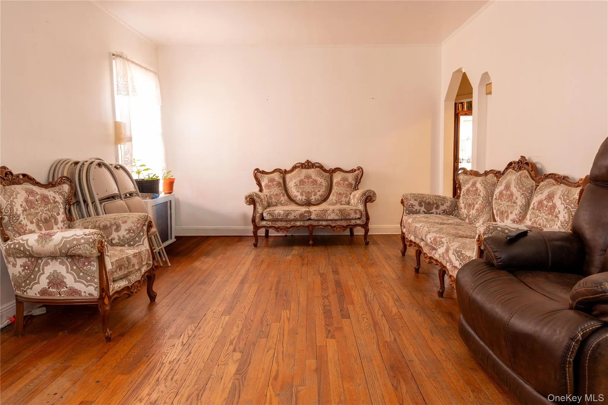 Living room featuring hardwood / wood-style floors and arched walkways Living room featuring hardwood / wood-style floors and arched walkways