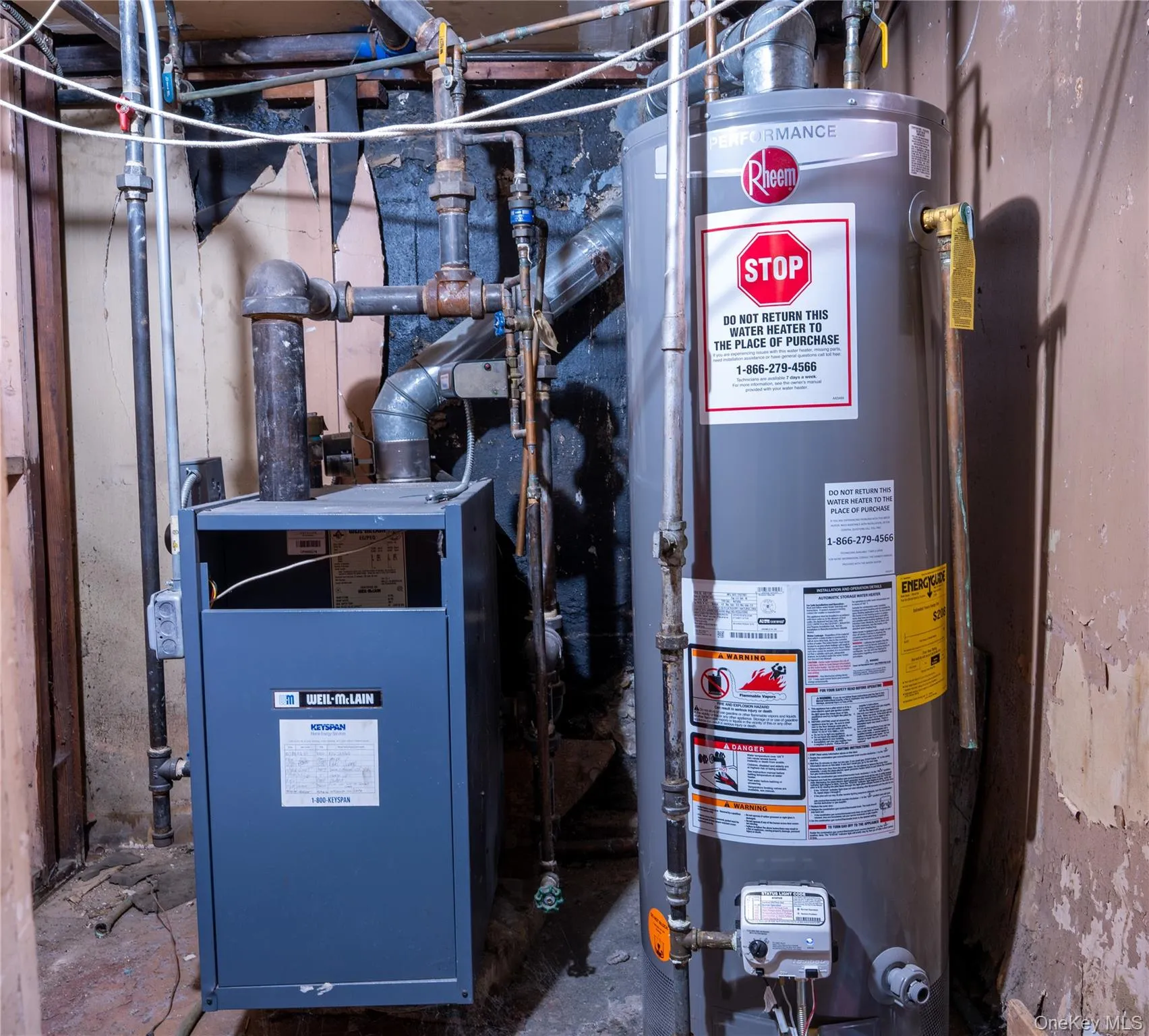 Utility room with water heater and boiler heating unit Utility room with water heater and boiler heating unit