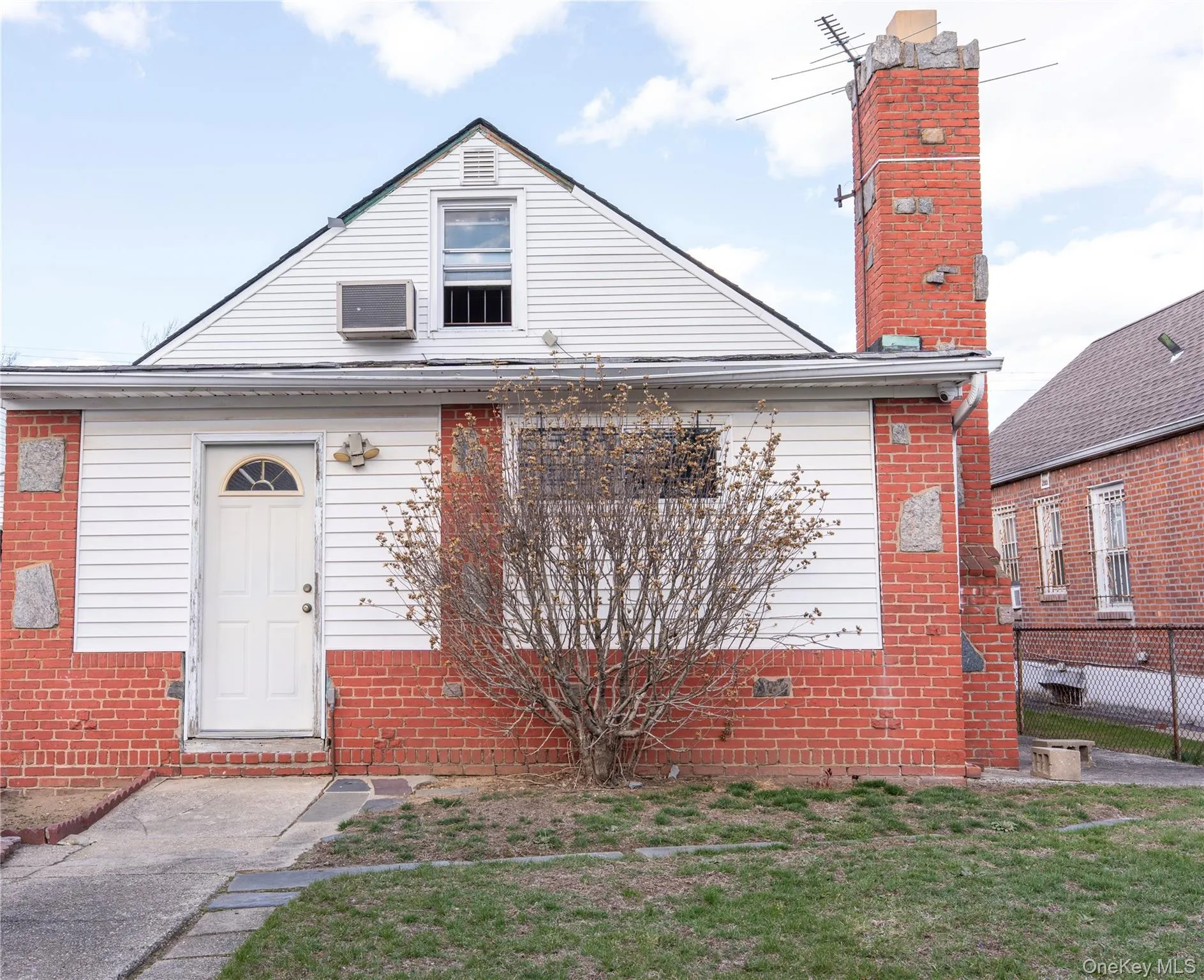 Bungalow-style home with a chimney, brick siding, and a front yard Bungalow-style home with a chimney, brick siding, and a front yard