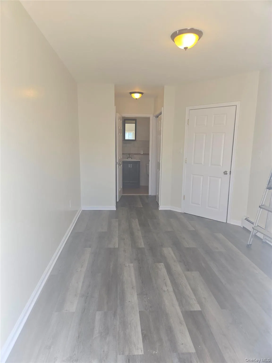 Unfurnished living room with dark wood finished floors and baseboards Unfurnished living room with dark wood finished floors and baseboards