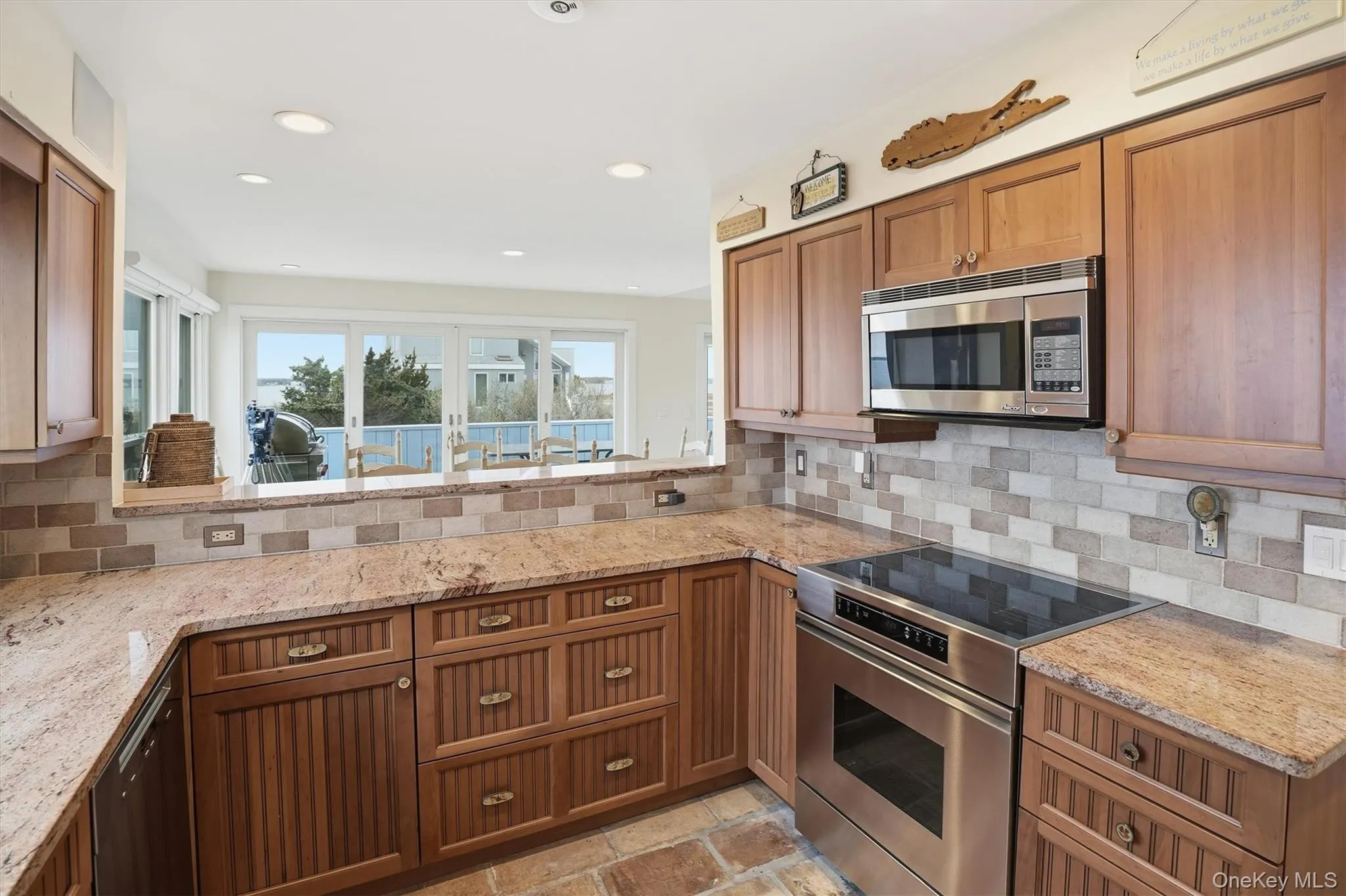 Kitchen with stainless steel appliances, light stone counters, wood finish cabinetry, and recessed lighting Kitchen with stainless steel appliances, light stone counters, wood finish cabinetry, and recessed lighting