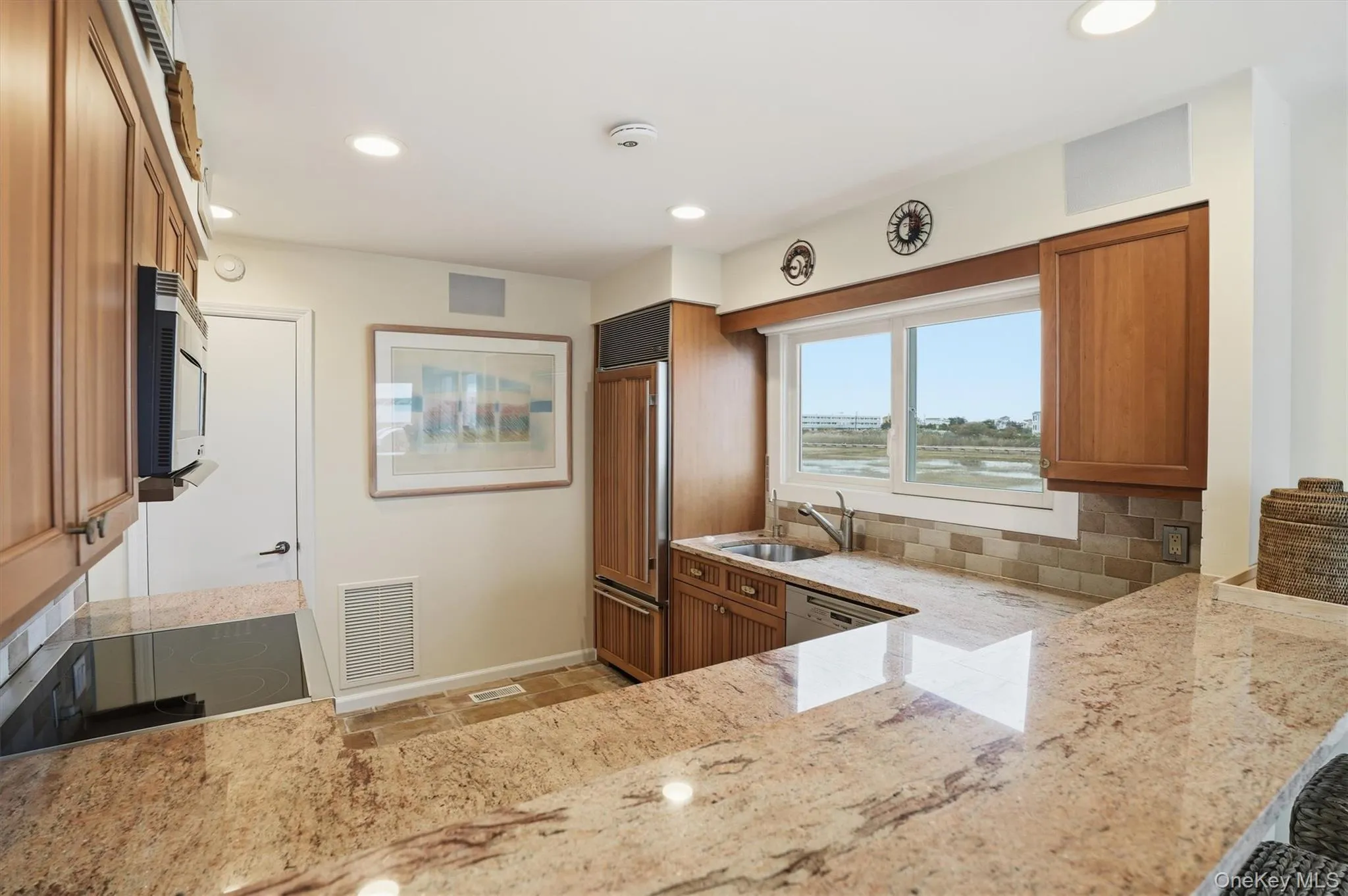 Kitchen with wood finish cabinetry, light stone countertops, and recessed lighting Kitchen with wood finish cabinetry, light stone countertops, and recessed lighting