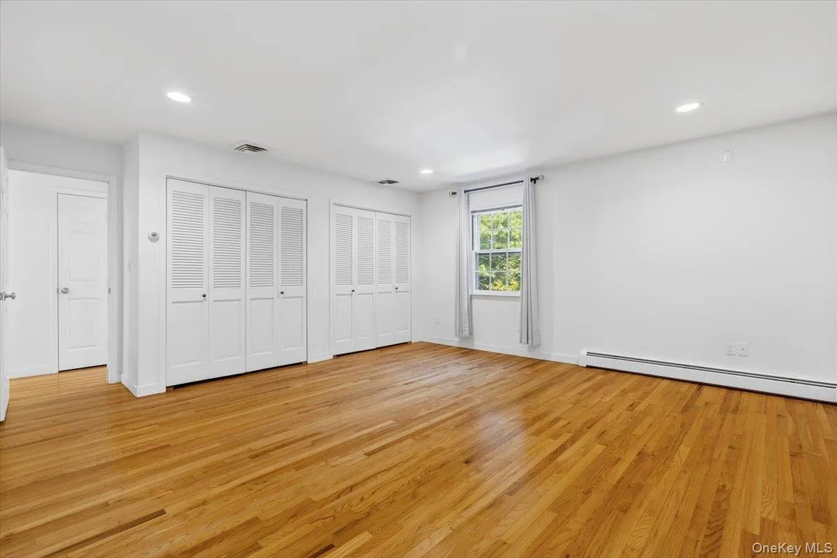 The large Primary Bedroom boasts two roomy custom double closets, recessed lights and hardwood floors. The large Primary Bedroom boasts two roomy custom double closets, recessed lights and hardwood floors.