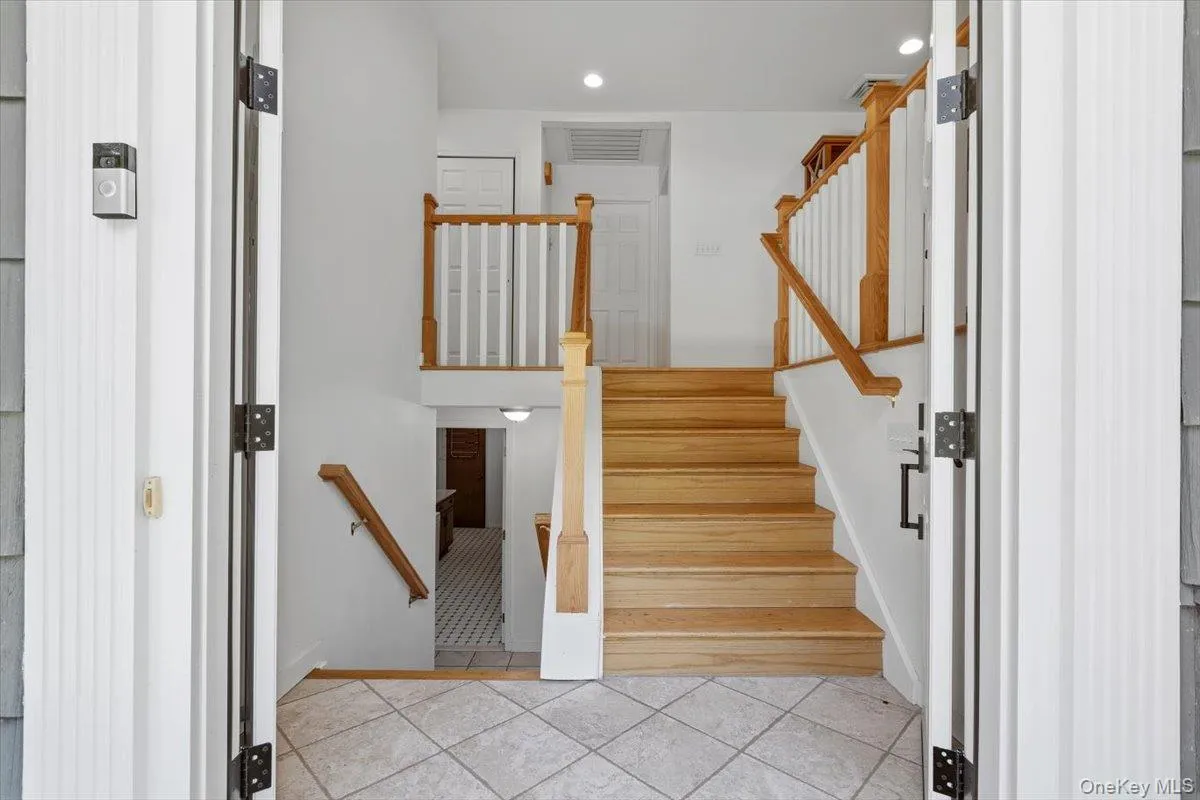 Through the two new double doors entry is the foyer with wood stirs and wood railing leading to the main living level. Through the two new double doors entry is the foyer with wood stirs and wood railing leading to the main living level.