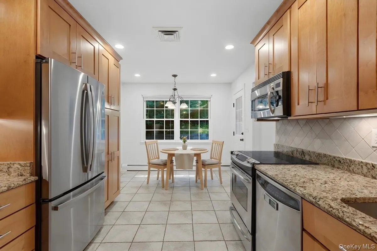 The updated Eat-in-Kitchen with wood cabinetry to the ceiling and granite counters. Windowed eating area. (Table/chairs virtually staged) The updated Eat-in-Kitchen with wood cabinetry to the ceiling and granite counters. Windowed eating area. (Table/chairs virtually staged)