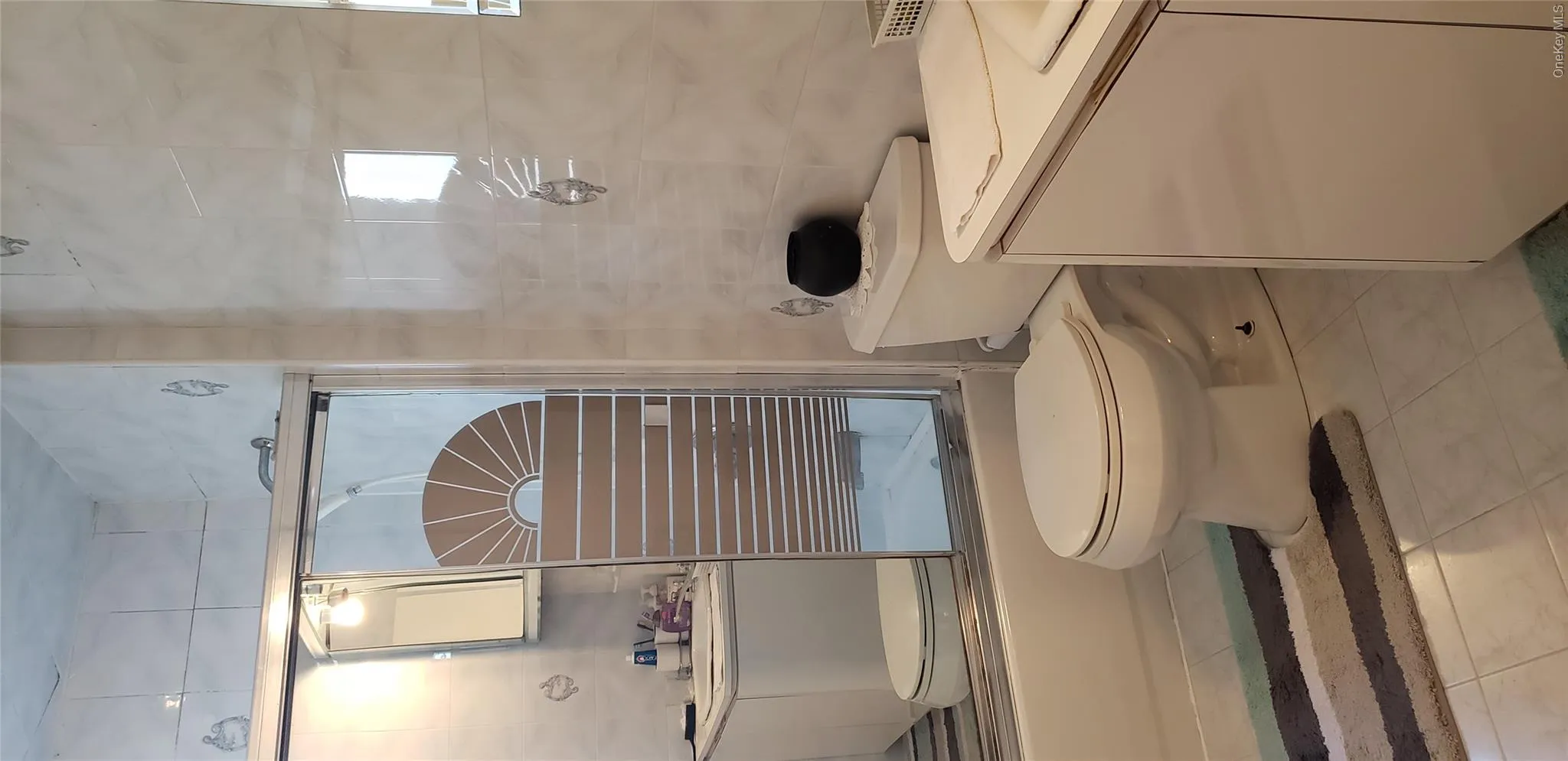 Full bath with vanity, bath / shower combo with glass door, and tile walls Full bath with vanity, bath / shower combo with glass door, and tile walls