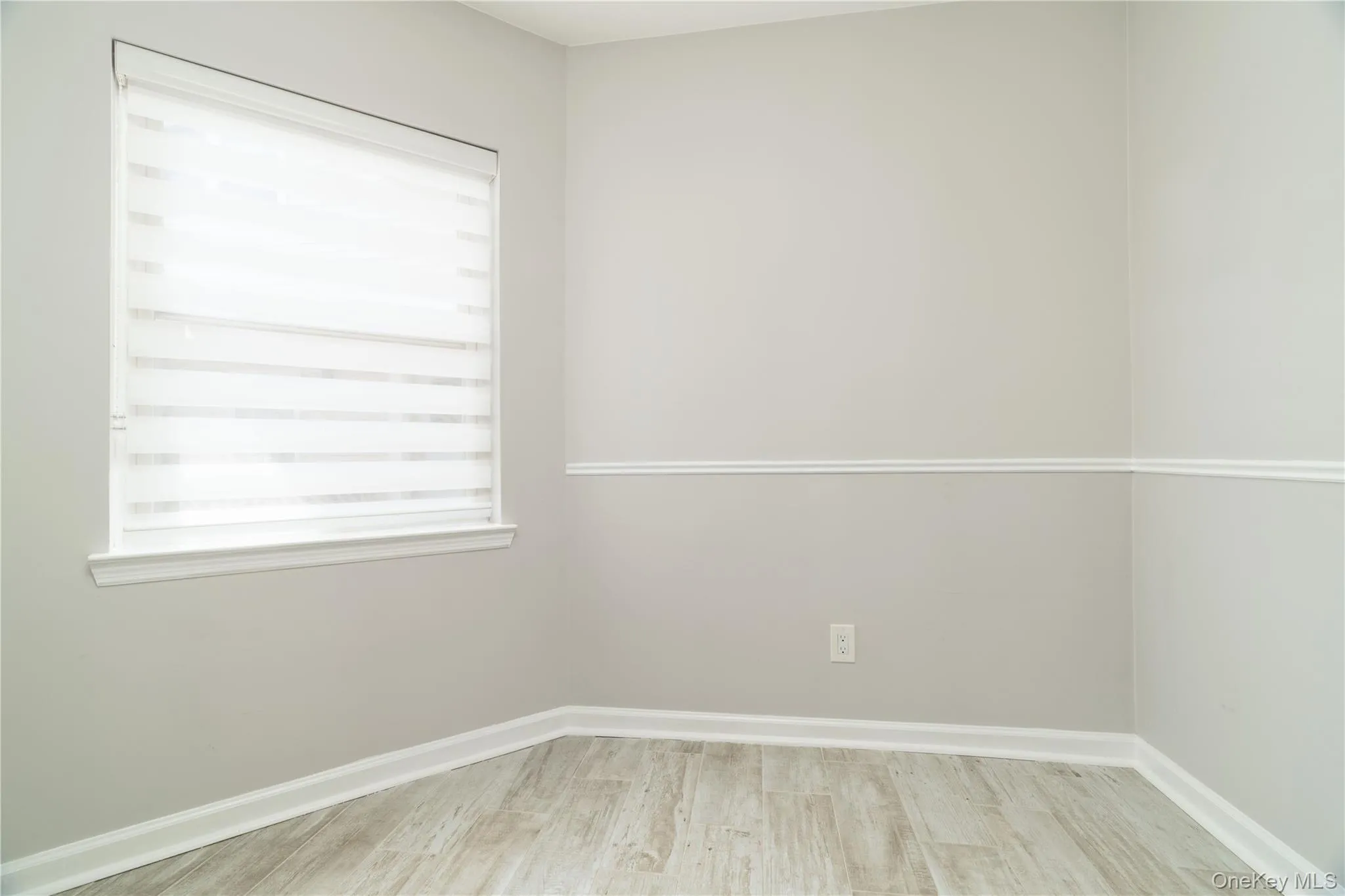 Empty room featuring wood finished floors and baseboards Empty room featuring wood finished floors and baseboards