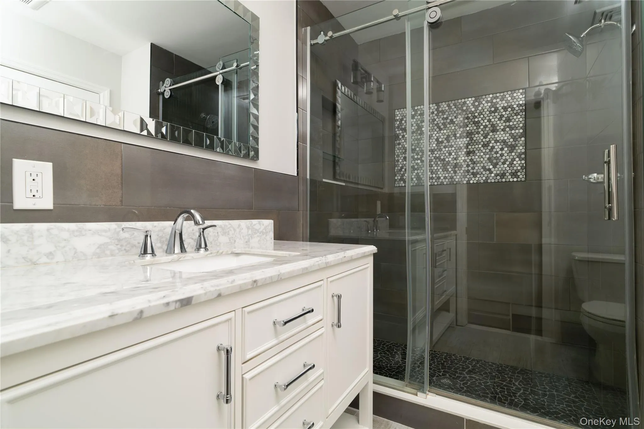 Full bathroom with vanity, a stall shower, and tile walls Full bathroom with vanity, a stall shower, and tile walls