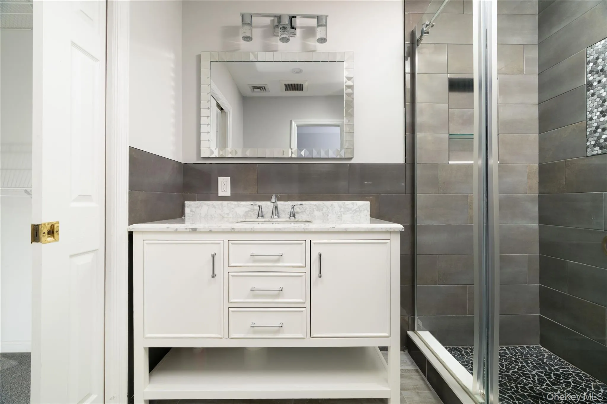 Full bath featuring vanity and a shower stall Full bath featuring vanity and a shower stall