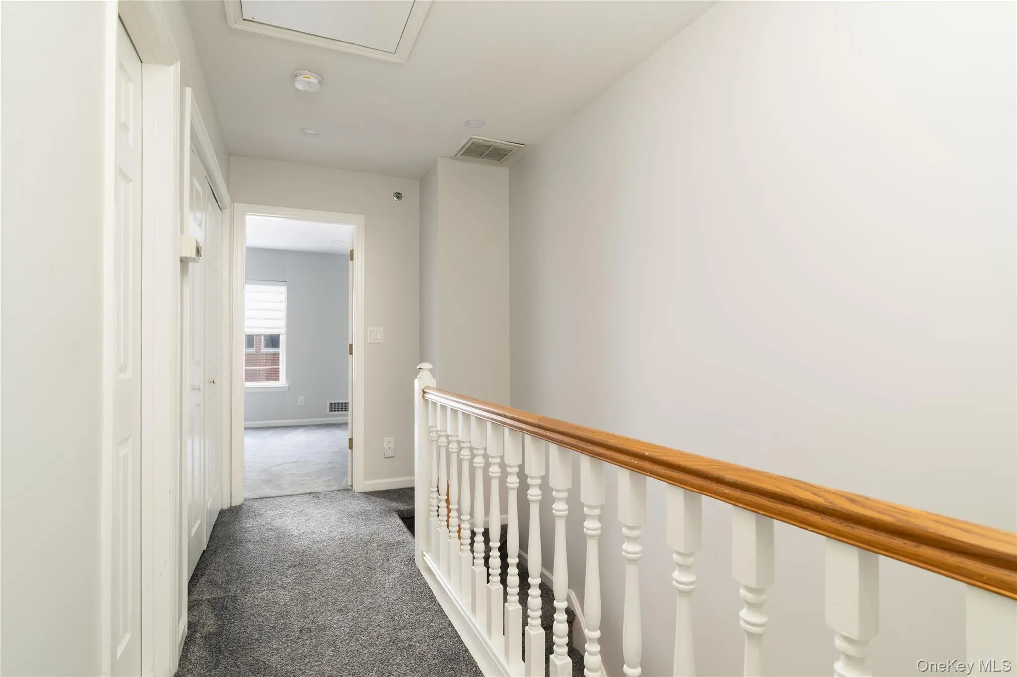 Hall with dark colored carpet and an upstairs landing Hall with dark colored carpet and an upstairs landing