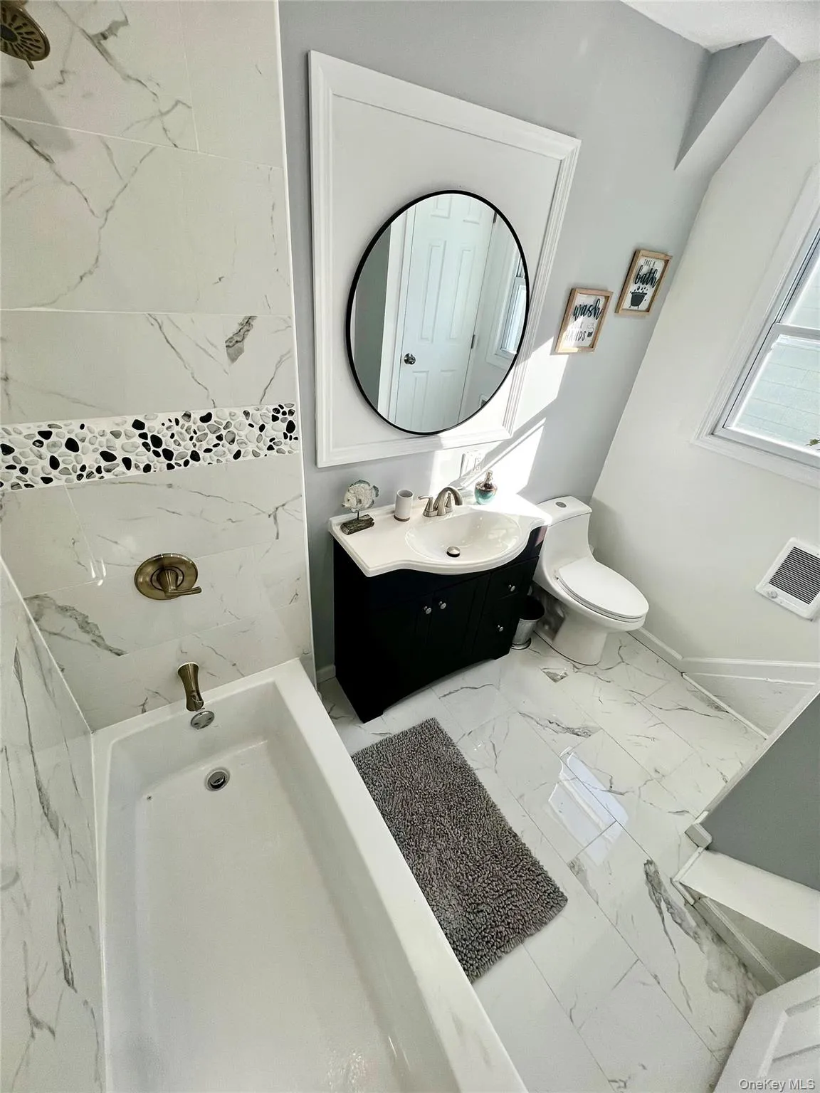 Bathroom featuring a bath, vanity, light marble finish floors, and a shower Bathroom featuring a bath, vanity, light marble finish floors, and a shower