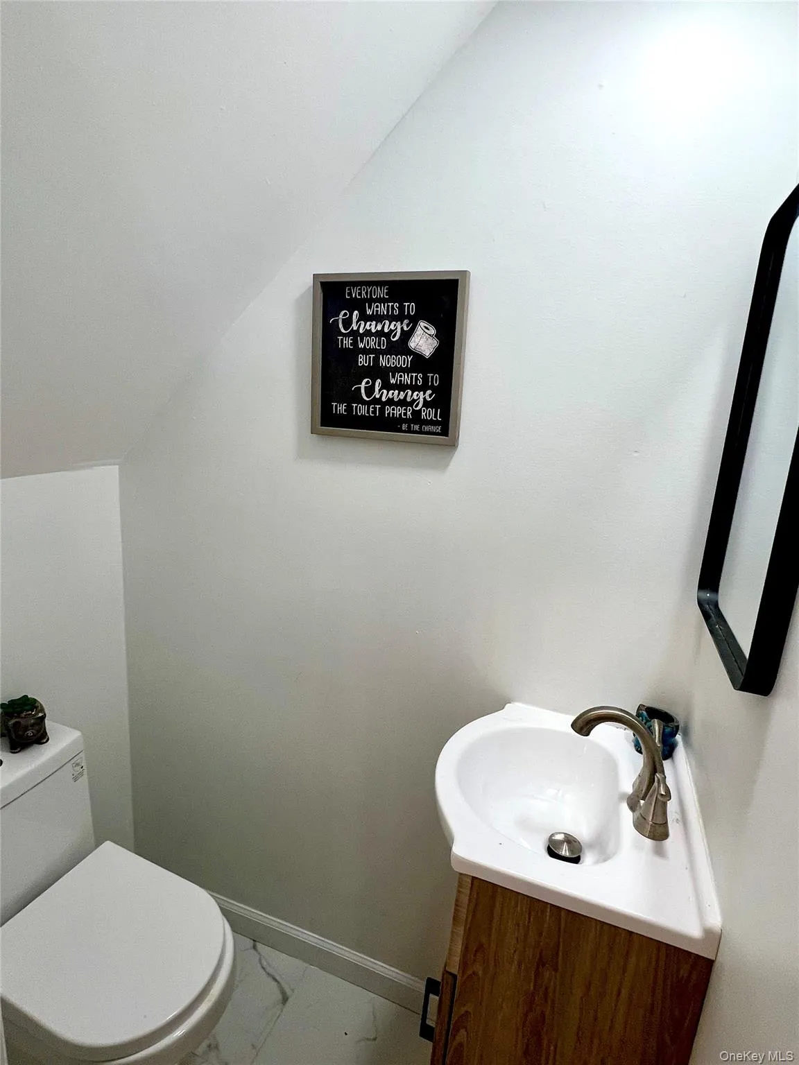 Bathroom with marble look tile flooring, vanity, and vaulted ceiling Bathroom with marble look tile flooring, vanity, and vaulted ceiling