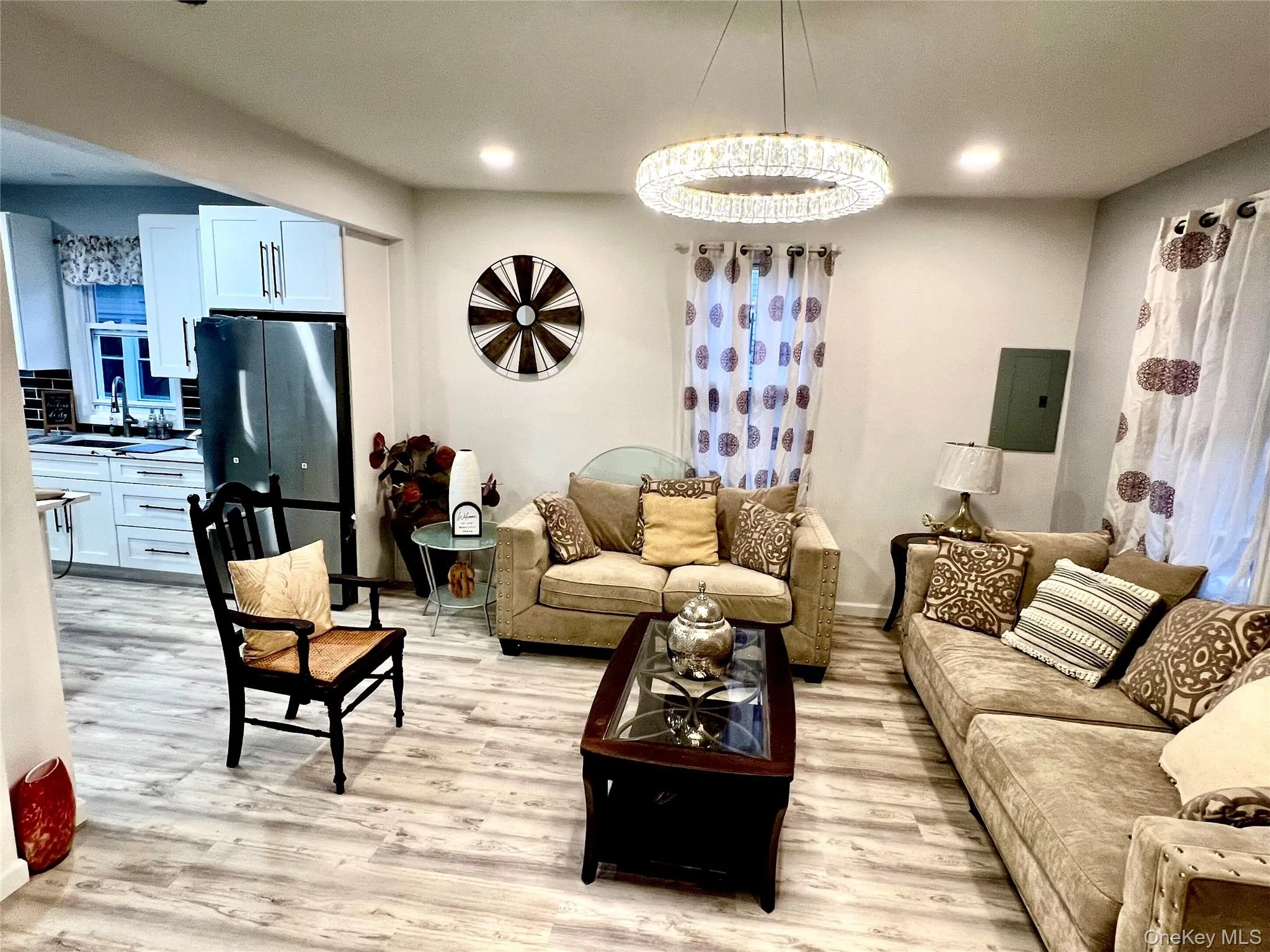 Living area with light wood-type flooring, electric panel, and recessed lighting Living area with light wood-type flooring, electric panel, and recessed lighting