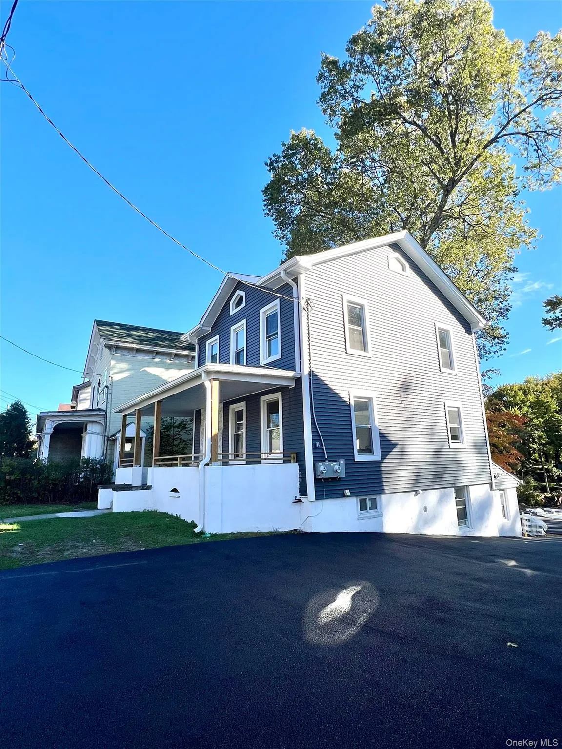 View of side of property with covered porch and a yard View of side of property with covered porch and a yard