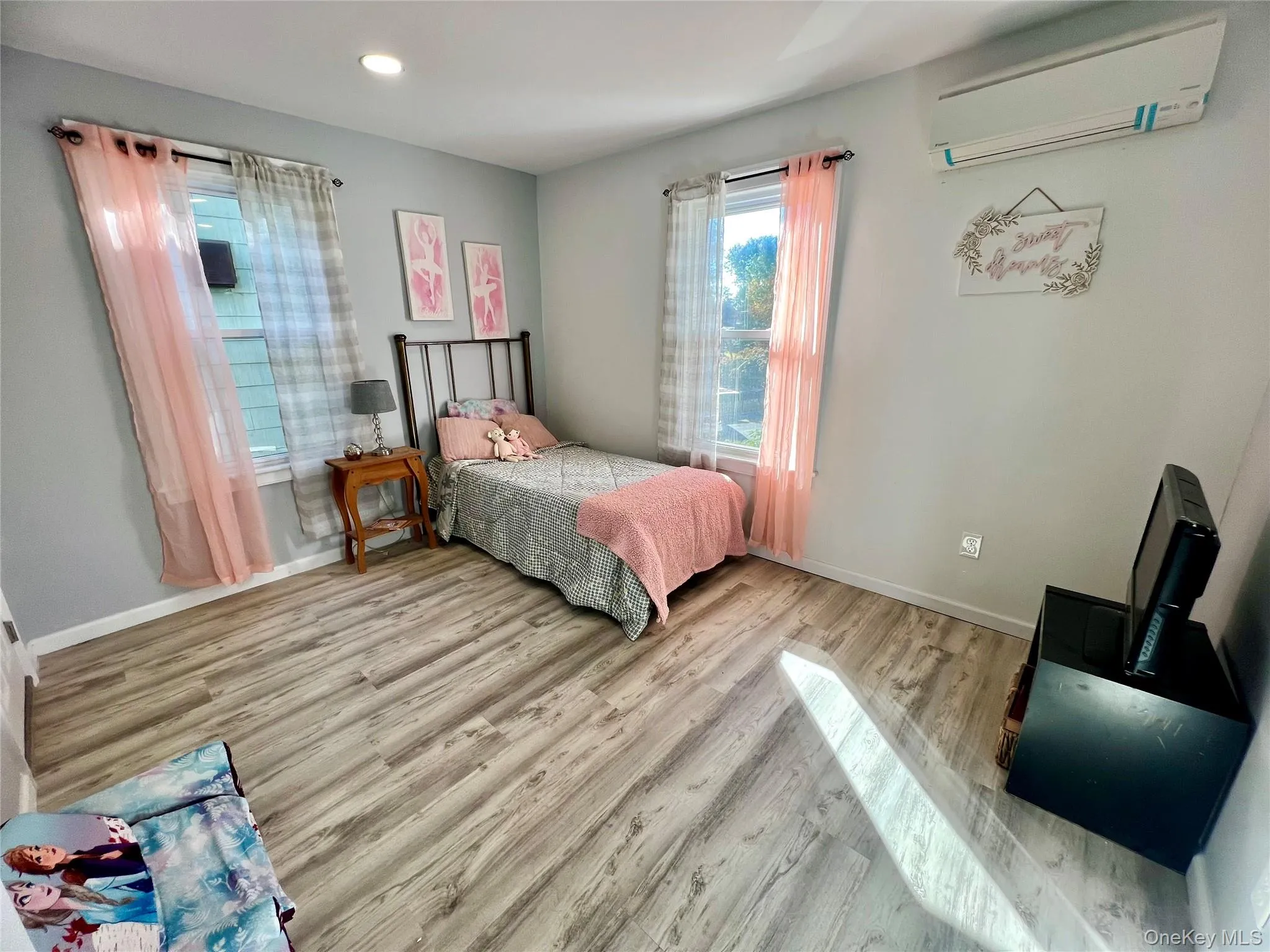 Bedroom featuring wood finished floors, a wall mounted AC, and recessed lighting Bedroom featuring wood finished floors, a wall mounted AC, and recessed lighting