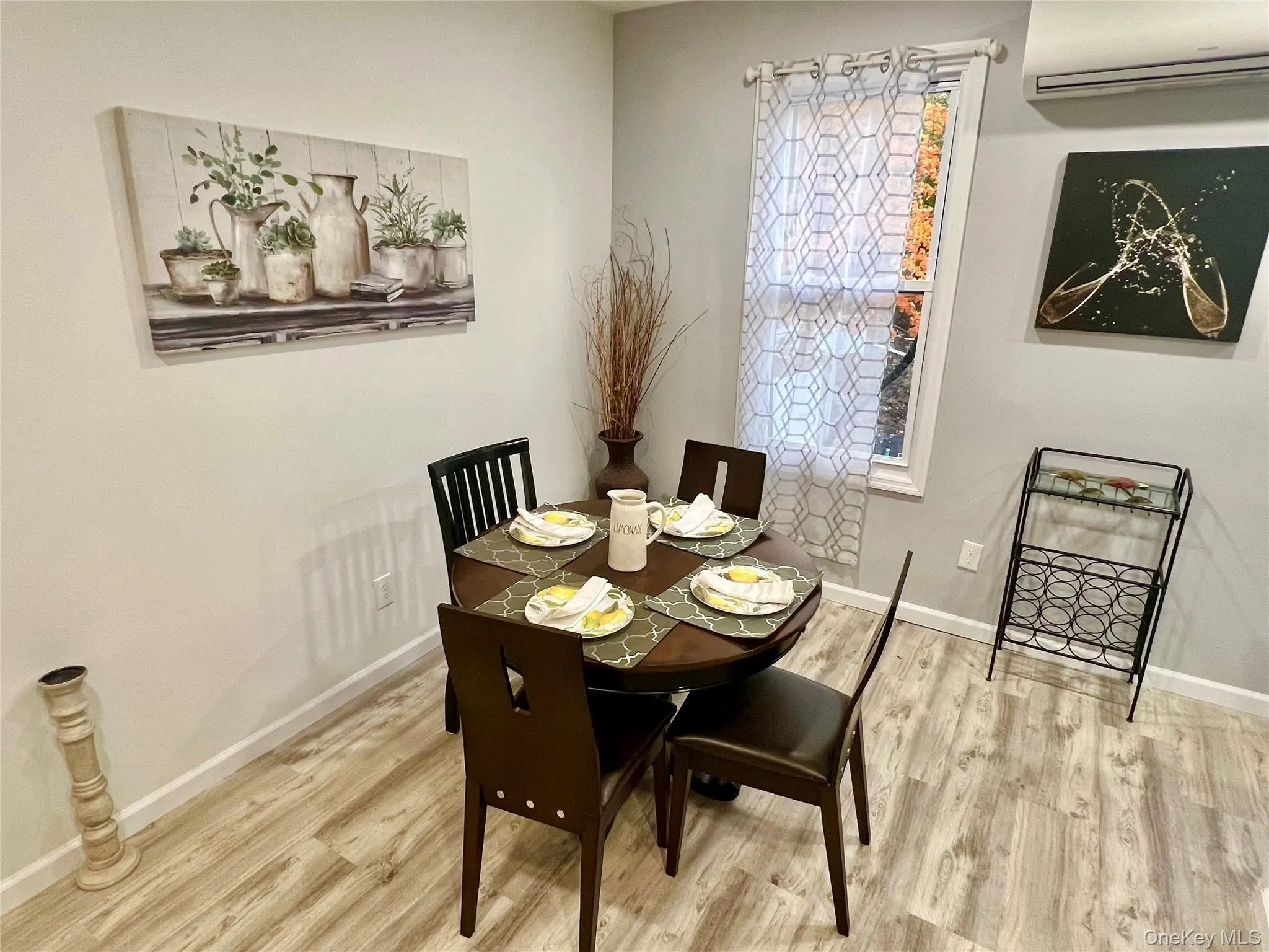Dining space featuring a wall mounted air conditioner and light wood finished floors Dining space featuring a wall mounted air conditioner and light wood finished floors