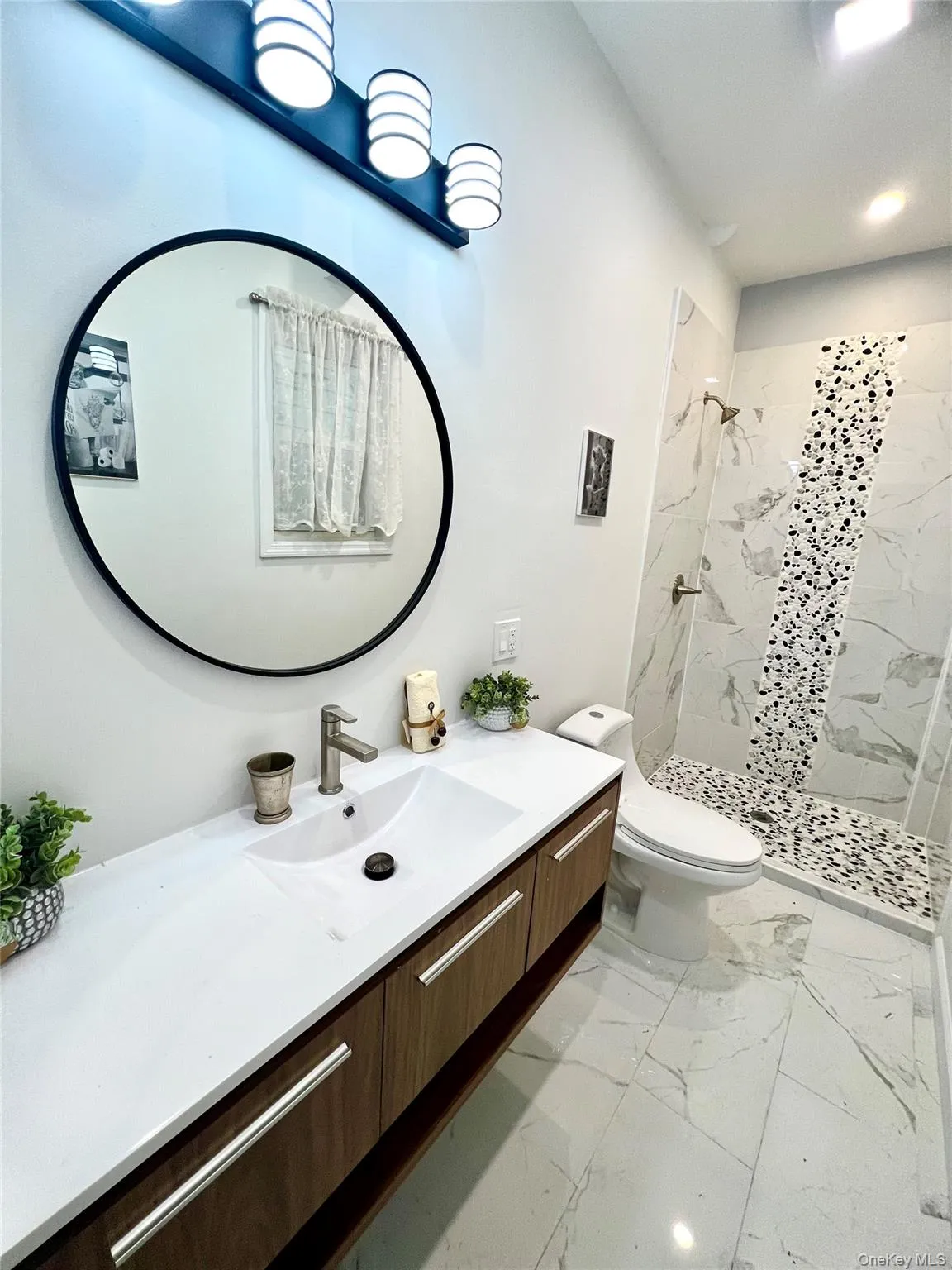 Bathroom with vanity, light marble finish floors, a shower stall, and recessed lighting Bathroom with vanity, light marble finish floors, a shower stall, and recessed lighting