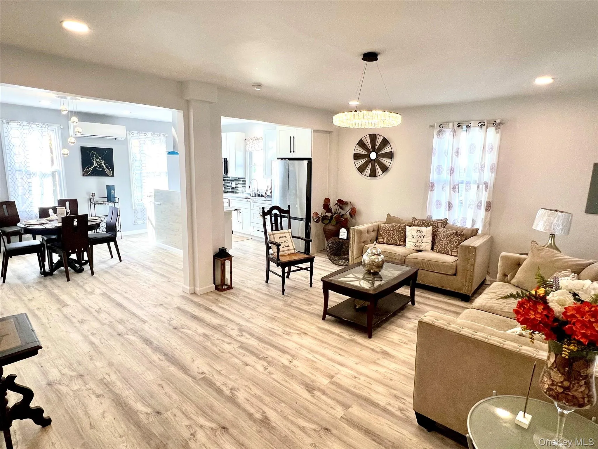 Living area with recessed lighting, light wood-style floors, and a wall unit AC Living area with recessed lighting, light wood-style floors, and a wall unit AC