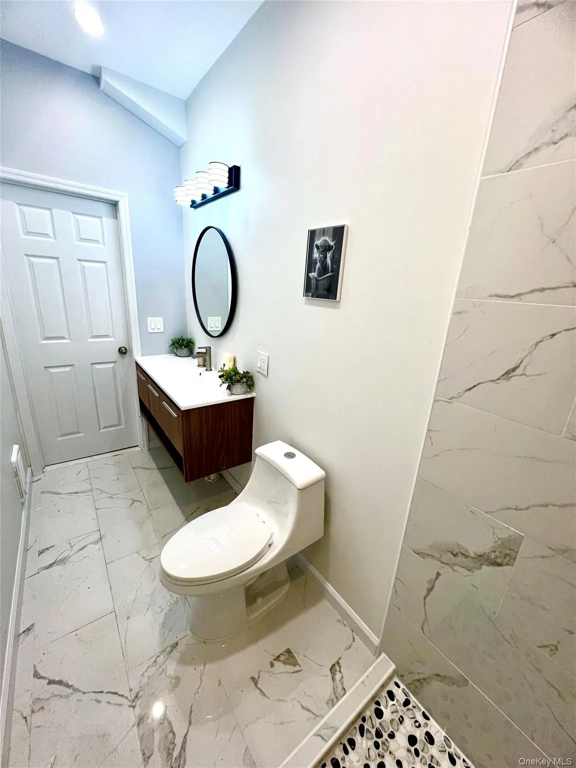 Bathroom featuring light marble finish flooring and vanity Bathroom featuring light marble finish flooring and vanity