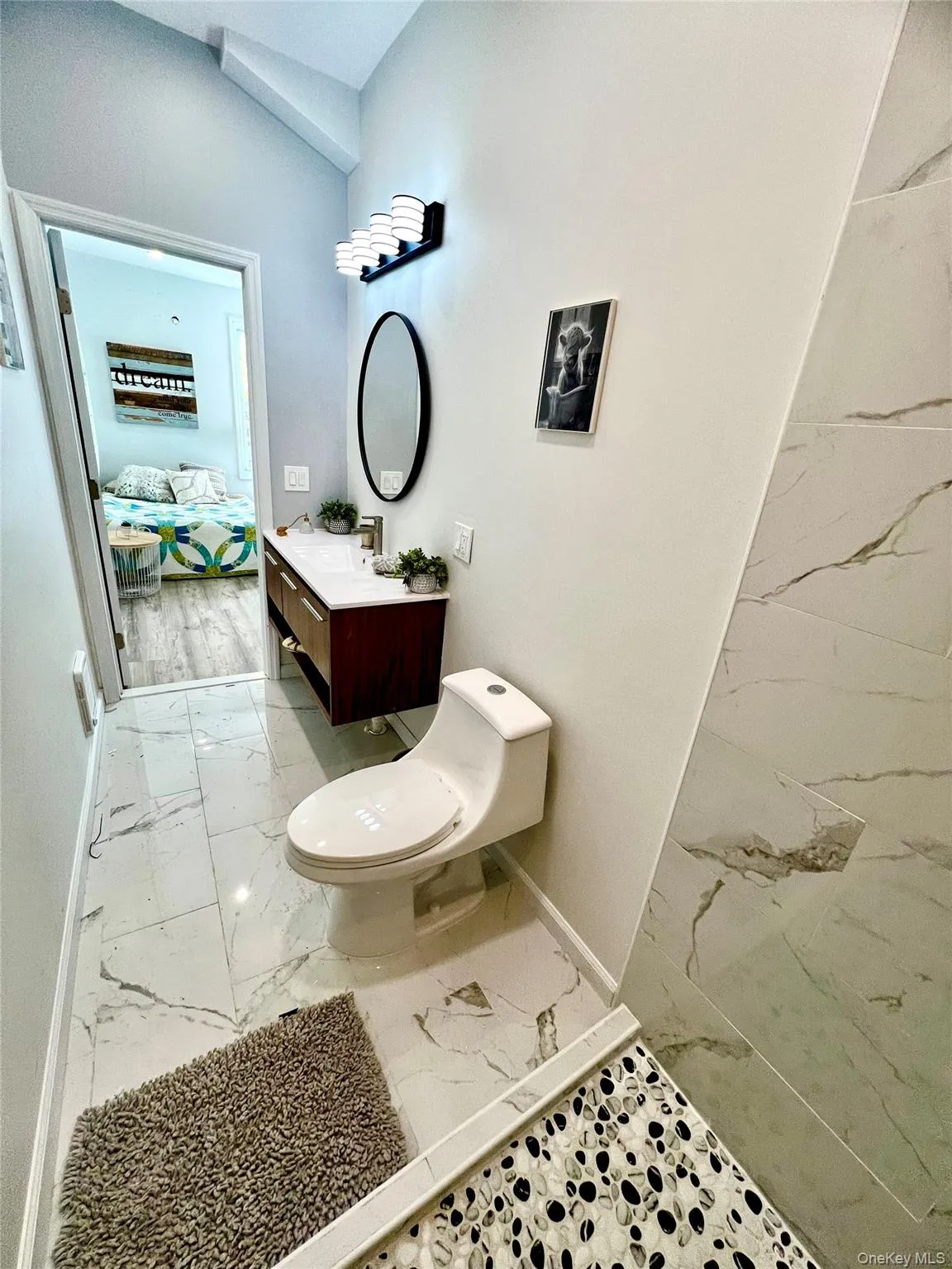 Ensuite bathroom with light marble finish flooring and vanity Ensuite bathroom with light marble finish flooring and vanity