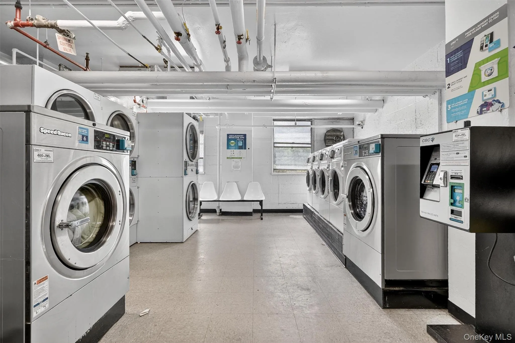 Communal laundry room with washer and dryer, stacked washing machine and dryer, and light flooring Communal laundry room with washer and dryer, stacked washing machine and dryer, and light flooring