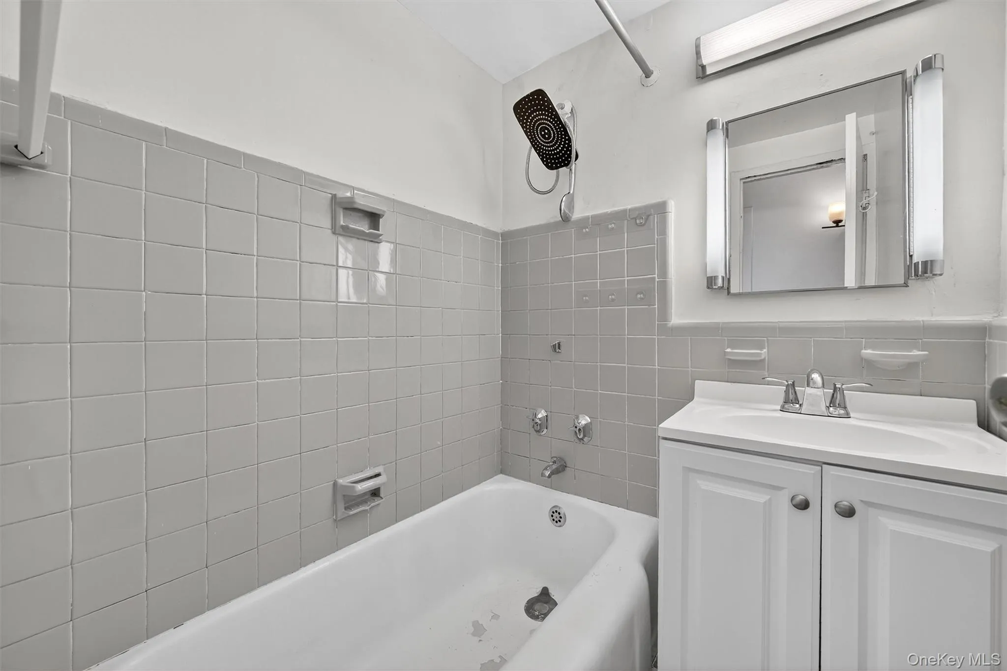 Bathroom with vanity, tile walls, and shower combination Bathroom with vanity, tile walls, and shower combination