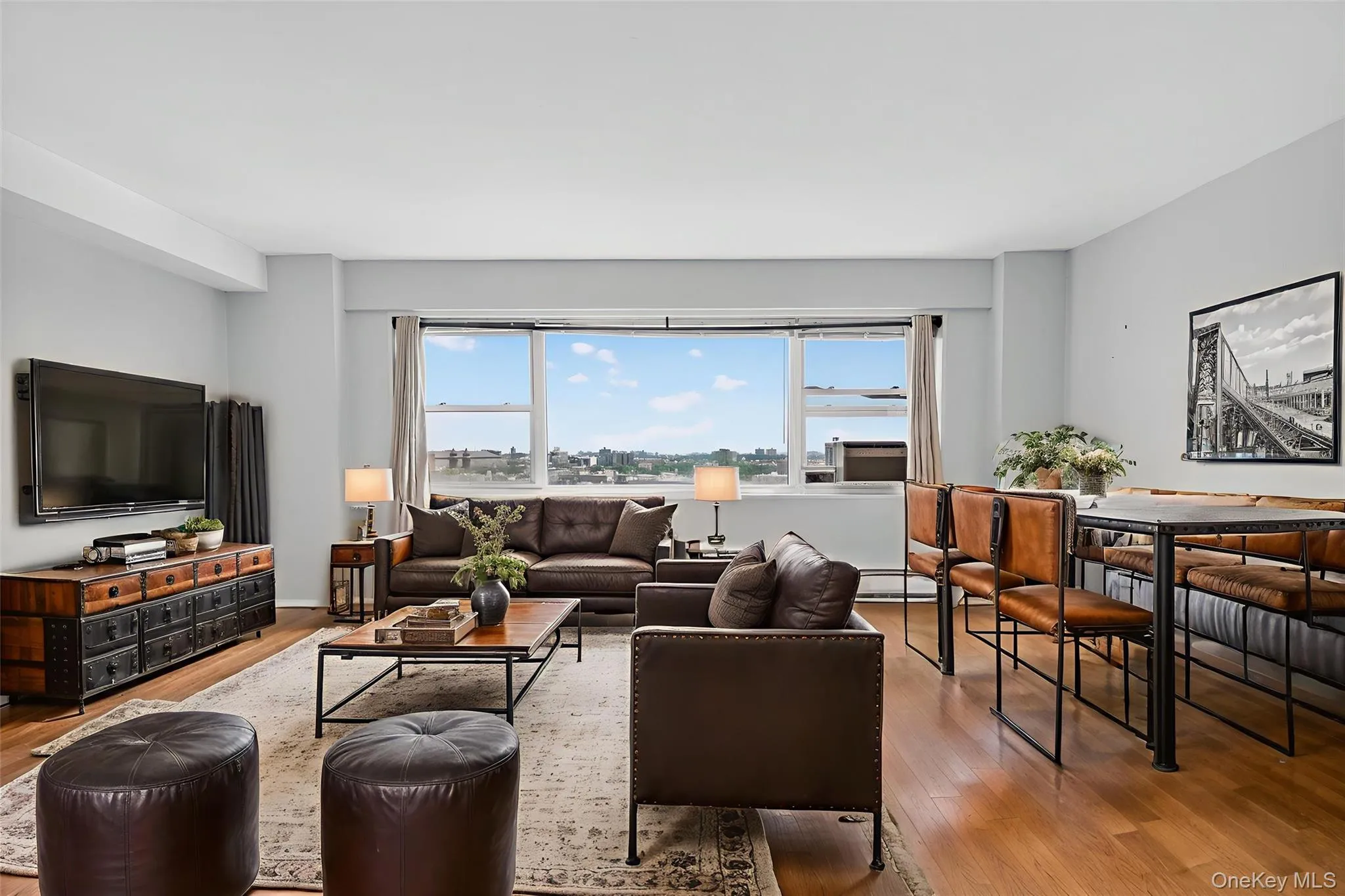 *Virtually Staged* Living area with plenty of natural light, wood finished floors, and a baseboard heating unit *Virtually Staged* Living area with plenty of natural light, wood finished floors, and a baseboard heating unit