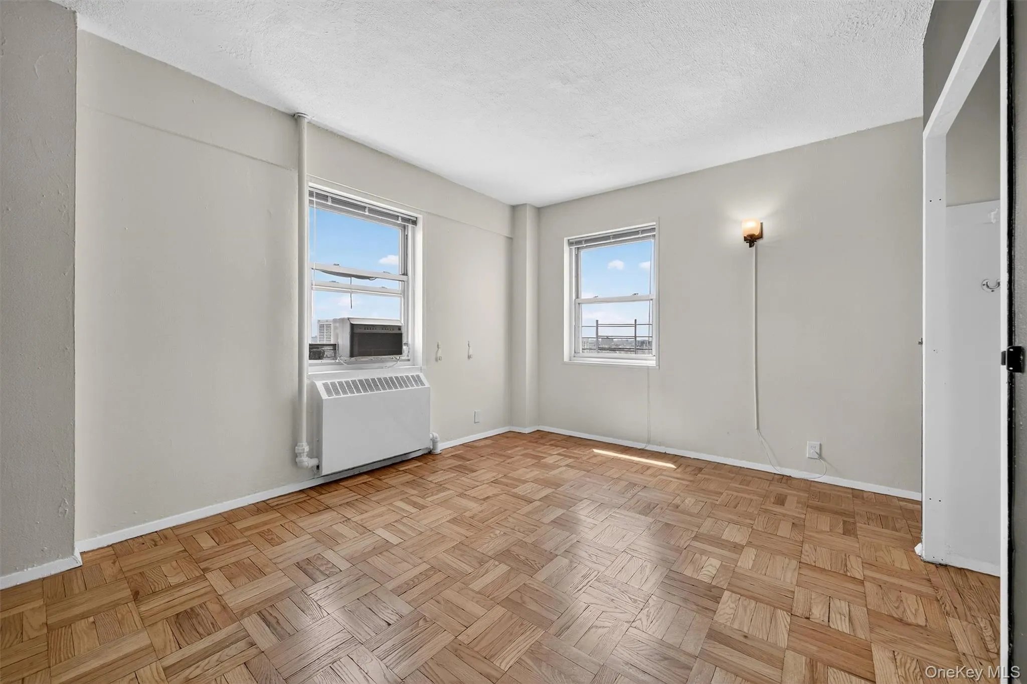 Unfurnished room with radiator heating unit, a textured ceiling, and cooling unit Unfurnished room with radiator heating unit, a textured ceiling, and cooling unit