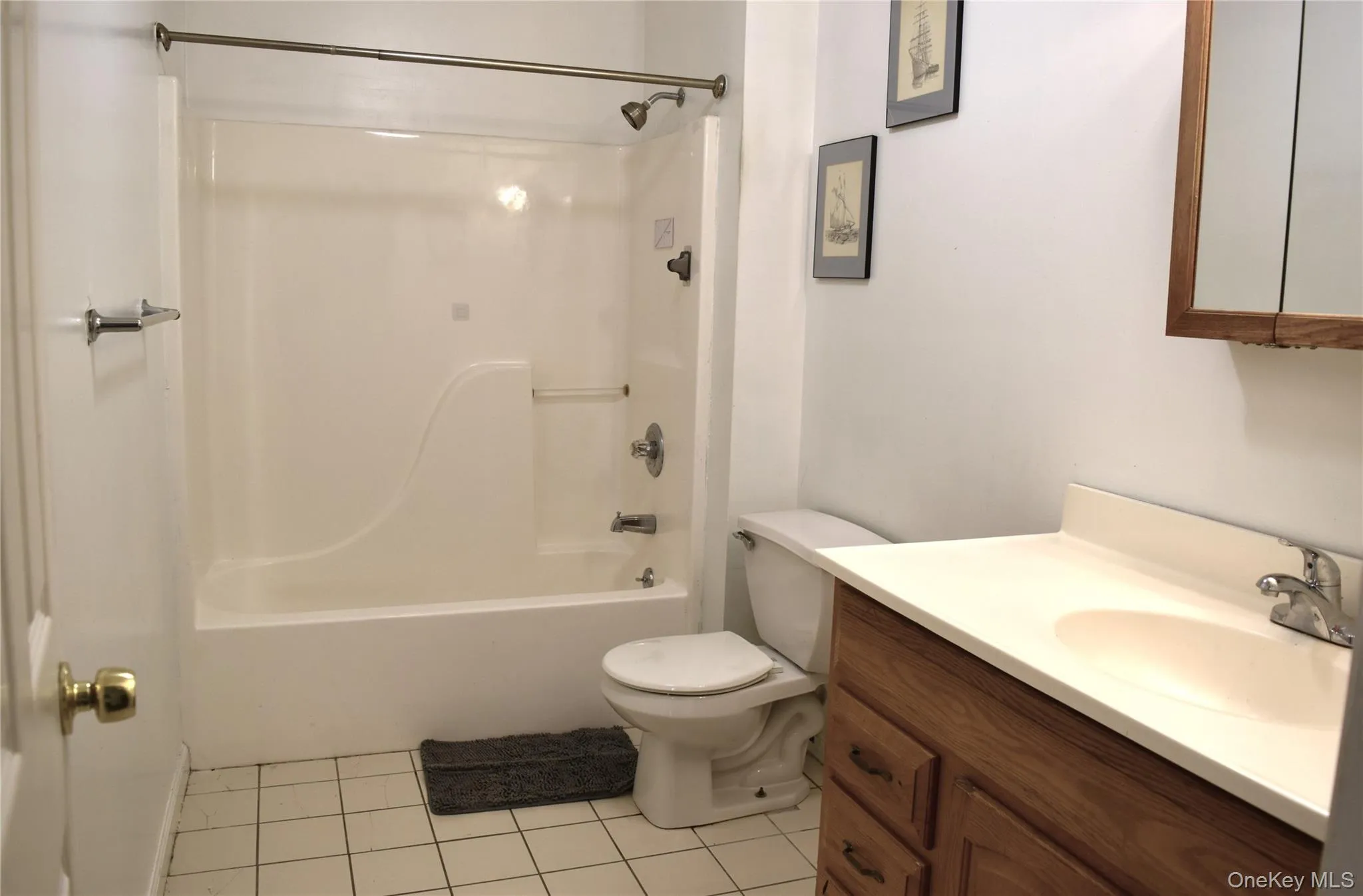 Bathroom with tile patterned floors, vanity, toilet, and shower / bathtub combination Bathroom with tile patterned floors, vanity, toilet, and shower / bathtub combination