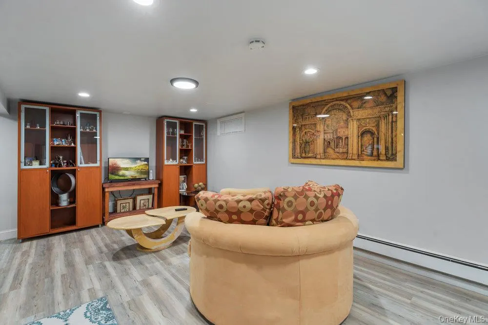 Living area featuring light wood-type flooring, recessed lighting, and baseboard heating Living area featuring light wood-type flooring, recessed lighting, and baseboard heating