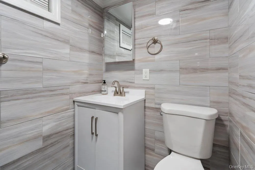 Half bath with vanity and tile walls Half bath with vanity and tile walls