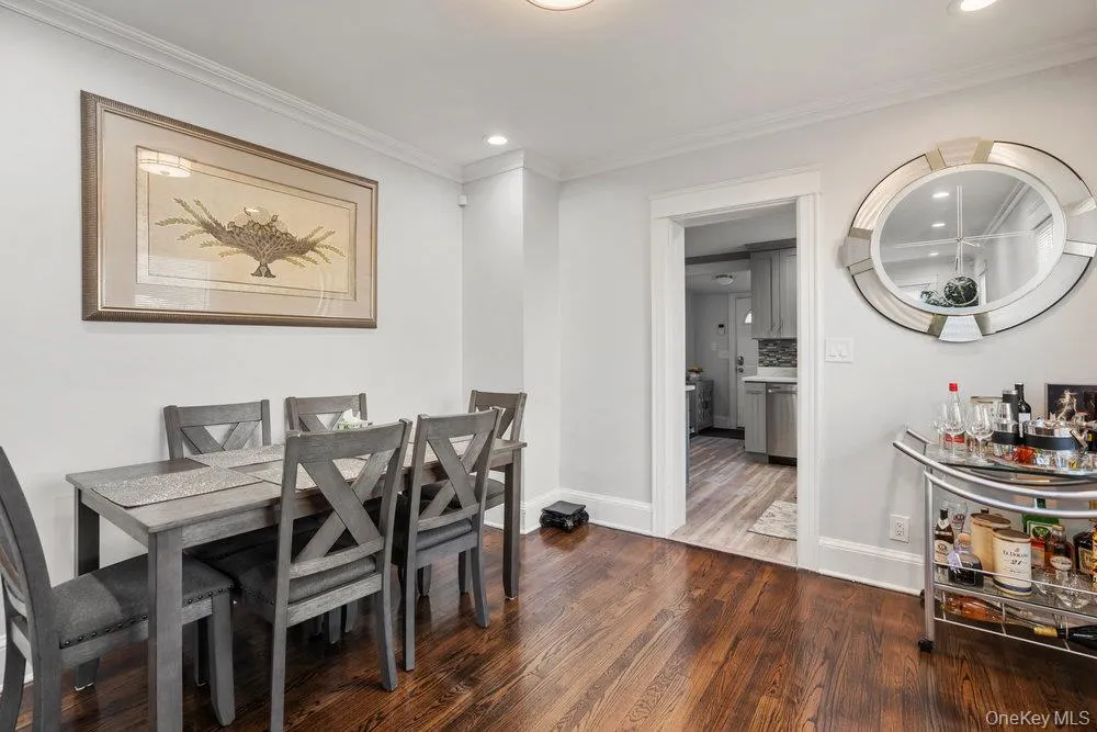 Dining space with dark wood-style floors, crown molding, and recessed lighting Dining space with dark wood-style floors, crown molding, and recessed lighting
